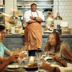 a chef standing in front of a table full of people