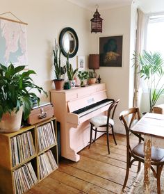 a living room filled with furniture and a pink piano in front of a large window