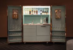 an open cabinet with bottles and glasses in it