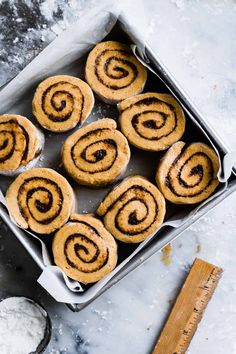 several cinnamon rolls in a baking tin on a table