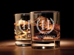 two personalized glasses sitting on top of a wooden table