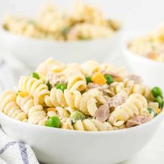 three bowls filled with pasta salad and peas