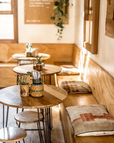 a table with some plants on top of it in a room filled with wooden tables and chairs