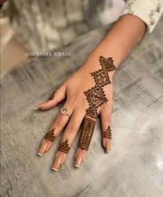 a woman's hand with henna tattoos on it