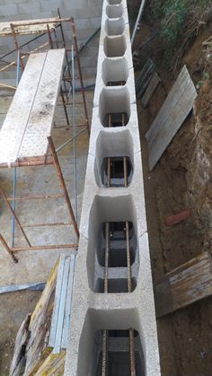 a cement block with several holes in the middle and some scaffolding around it