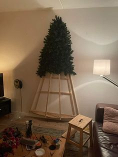 a living room filled with furniture and a christmas tree on top of a wooden shelf