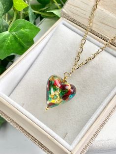 "Sweet, Heart pendant necklace of genuine Murano glass from the artisans in Murano, Italy! You will love this pretty glass pendant that is full of color and whimsy. Show her that you love her with this heart of multi colors swirling and dancing. The glass has 14k gold foil within them to add to the sparkle of colors of gold, red and green ! The gorgeous chain is Gold Fill with lobster claw clasp. The glass heart bead is about 3/4 of an inch and then the drop of the total pendant is about 1.25 in Elegant Glass Heart Pendant Necklaces, Elegant Glass Heart Charm Necklace, Green Heart Cut Necklace For Gift, Green Heart Necklace For Valentine's Day Gift, Red Murano Glass Necklace For Gift, Glass Heart Beads Necklace As A Gift, Heart-shaped Glass Necklaces For Jewelry Making, Glass Necklaces With Heart Beads For Gifts, Handmade Green Heart Necklace As Gift