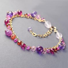 Sweet, delicate,  luxurious layering, gold filled bracelet with lots of beautiful, colorful precious gemstone dangles. In the center of the bracelet swings unique carved, flower shaped, purple with silver sheen sapphire and on its sides dangle rounds and roundels of gold and orange sapphires, ruby corundum , purple amethyst, garnet, hot pink sapphire and  pink pink topaz.  All of the gems are wrapped on gold filled head pins and dangle from a shimmery gold filled chain. This bracelet is completed with couple of rose quartz drops and secure gold filled, spring ring clasp and short extender.  Adjustable from 7.25 to 8.5inches. Gemstone roundels from 3mm to 7mm Thank you for looking! Please contact me if you have any questions or requests. Free domestic first class shipping. Faster shipping a Elegant Pink Amethyst Beaded Bracelets, Bracelet Layering, Topaz Bracelet, Dangle Bracelet, Garnet Jewelry, Pink Topaz, Orange Sapphire, Ruby Sapphire, Head Pins