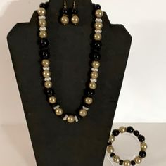 Hand Crafted Necklace, Bracelet, And Earrings New Pearl Necklace Set - 3 Pieces Black And Gold Beaded Necklace Set - Necklace Earrings Bracelet The Gold Beads Are Faux Pearls, The Black Beads Are Glass. The Spacers Are Glass And Metal. White With Gold Rim Spacers Wavy Metal Spacers Handmade 12mm Glass Beads 12mm Faux Pearls Necklace - 20” Drop Earrings- 1 3/8” Stretch Bracelet- 6.5” Statement This Set Is Elegant. Pair It With A Formal Gown, A Black Dress, A Suit Or A Pair Jeans. Casual And/Or Fo Formal Black Round Jewelry Sets, Classic Gold Jewelry With Black Beads, Elegant Black Adjustable Jewelry Sets, Black Beaded Costume Jewelry, Classic Black Beaded Jewelry As Gift, Classic Adjustable Jewelry For Party, Black Round Beads Jewelry Set As Gift, Black Round Beads Jewelry Set For Gift, Black Jewelry Set With Round Beads For Gift