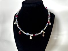 This colorful pearl necklace combines pink, raspberry, and blue crystal beads to make a necklace that's eclectic and colorful, and adds a fun pop to any look, formal or casual. Pearls and crystal beads hang from the necklace, giving it a charm effect. Necklace is adjustable and can be extended for a looser fit. Pink Pearl Dangle Necklaces, Handmade Pink Crystal Beaded Necklaces, Handmade Pink Crystal Choker Necklace, Dainty Handmade Beaded Necklaces For Party, Handmade Dainty Beaded Necklace For Party, Dainty Handmade Beaded Necklace For Party, Elegant Charm Necklaces With Colorful Beads For Gift, Colorful Crystal Beads Necklace For Gift, Colorful Crystal Bead Necklaces As Gifts