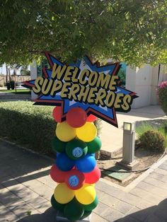 a welcome sign in the shape of a tree with balloons attached to it that says, welcome superheros