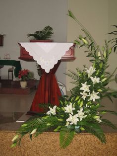 flowers and greenery are placed in front of the alter