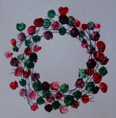 a wreath made out of red, green and pink flowers on a white background with the word love written across it