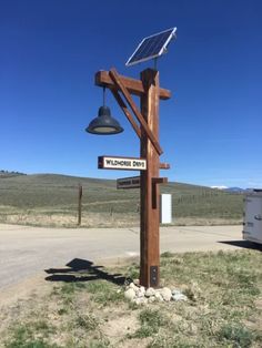 a pole with a solar panel attached to it next to a street sign and lamp post