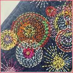 a close up of a piece of cloth with colorful designs on it and buttons in the center