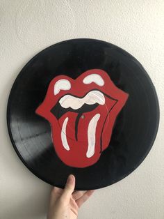 a record with the rolling stones'tongue painted on it is being held by a hand