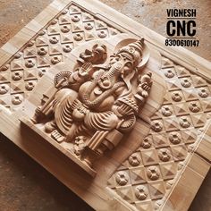 an intricately carved wooden block depicting the god ganesh