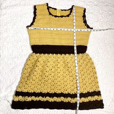 Beyond adorable fit and flare handmade crocheted mini dress in gold and brown. Sleeveless fitted top with back zipper. Open crochet skirt that's semi-full. Zipper is nylon. Worsted weight yarn. Note: it's pinned to fit the dress form. Material / acrylic yarn Care / machine wash For accurate fit, please compare measurements to a similar garment that fits you well. Make allowance for clothes underneath and to allow garment to drape properly. Size on tag / no tags, fits like a mediumish Measurement Fitted Brown Sleeveless Mini Dress, Fitted Crochet Lace Dress In Mini Length, Fitted Brown Crochet Top For Spring, Fitted Sleeveless Crochet Mini Dress, Fitted Sleeveless Crochet Lace Dress, Fitted Sleeveless Mini Dress With Crochet, Sleeveless Crochet Lace Mini Dress, Fitted Crochet Lace Top, Fitted Crochet Lace Top Mini Length