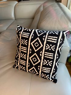 a black and white pillow sitting on top of a couch