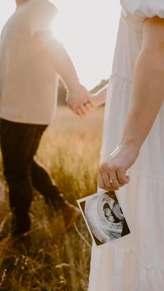 a man and woman holding hands in the middle of a field with an old photo