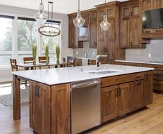 a large kitchen with wooden cabinets and white counter tops, an island in the middle