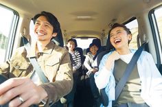 group of people sitting in the back seat of a car smiling at each other and laughing