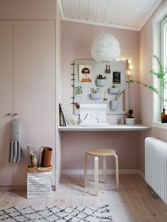 a room with pink walls and wooden flooring, including a white radiator