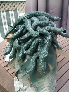 a bag full of green snakes sitting on top of a wooden table