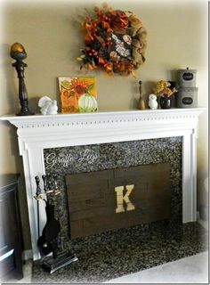 a fireplace with a clock above it and decorations on the mantle