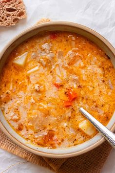 a bowl of soup with bread on the side