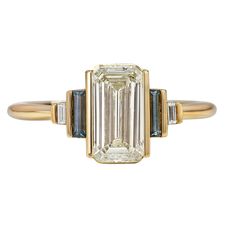 an emerald and diamond ring with three baguets in yellow gold plated silver