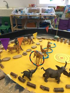 toy animals and zebras are arranged on a play table in a children's room