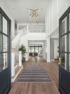 the inside of a house with an open door and stairs on each side of it