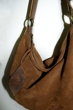 Handmade brown cognac suede medium size hobo bag The bag is closed with a metallic zip. Inside is unlined and there is a large cotton zipped pocket. The bag has an adjustable shoulder strap made with strong black leather. To add an extra touch to the bag you can buy the short handle which measures 18 inch in length and is made with beautiful black leather. This medium size hobo bag is a perfect bag for every moment Features : - Brown cognac suede, - Brown cognac leather strap, - Zipped bag, - Un Chic Brown Suede Hobo Bag, Brown Leather Trim Hobo Bag For Everyday, Brown Hobo Bag With Leather Trim For Everyday Use, Casual Suede Hobo Bag For Travel, Everyday Suede Shoulder Bag With Leather Trim, Everyday Suede Shoulder Bag With Zipper Closure, Brown Leather Hobo Bag With Suede Lining, Brown Suede Hobo Bag With Leather Handles, Suede Hobo Shoulder Bag With Zipper