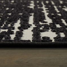 a black and white rug on top of a wooden floor