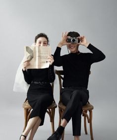 two people sitting on chairs and looking through binoculars