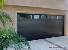 a garage door is shown with palm trees in the foreground and a house behind it