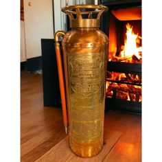 an old fashioned fire extinguisher sitting on the floor next to a fireplace