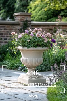 a planter filled with lots of flowers sitting on top of a stone walkway