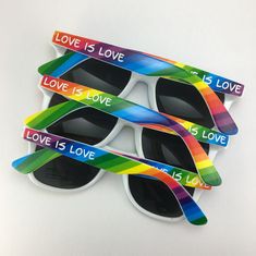 four pairs of sunglasses with the words love is love printed on them and rainbow colors