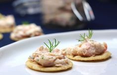 small crackers topped with crab salad on a white plate