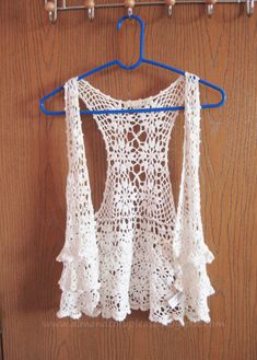 a crocheted top hanging on a clothes rack