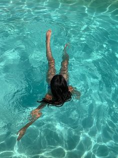 a woman floating in the water on top of a surfboard