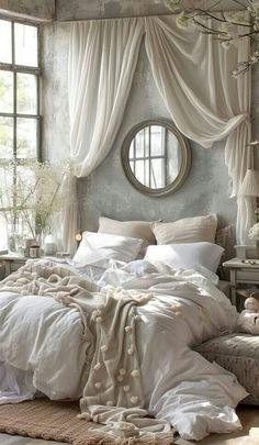 a bed with white sheets and pillows in front of a round mirror on the wall