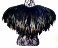 a mannequin with black feathers and lace on it's body, against a white background