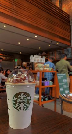 a starbucks drink sitting on top of a wooden table