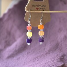 Square Glass Bead Earrings. Orange, Purple And Yellow. Nice And Bright For Spring/Summer! Handmade By Me. Brand New. Earrings Are 2 1/4 Inches Long. Purple Gemstone Bead Dangle Earrings, Purple Gemstone Beads Dangle Earrings, Purple Dangle Earrings With Gemstone Beads, Handmade Purple Beaded Earrings For Beach, Bohemian Purple Beaded Earrings For Beach, Purple Czech Glass Beaded Dangle Earrings, Purple Dangle Beaded Earrings For Beach, Purple Beaded Dangle Earrings For Beach, Purple Beaded Amethyst Earrings