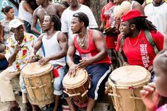 a group of men sitting next to each other holding drums