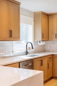 a kitchen with wooden cabinets and white counter tops, along with a dishwasher