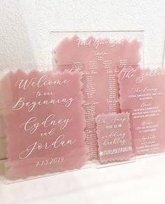 pink and white wedding programs displayed in clear acrylic